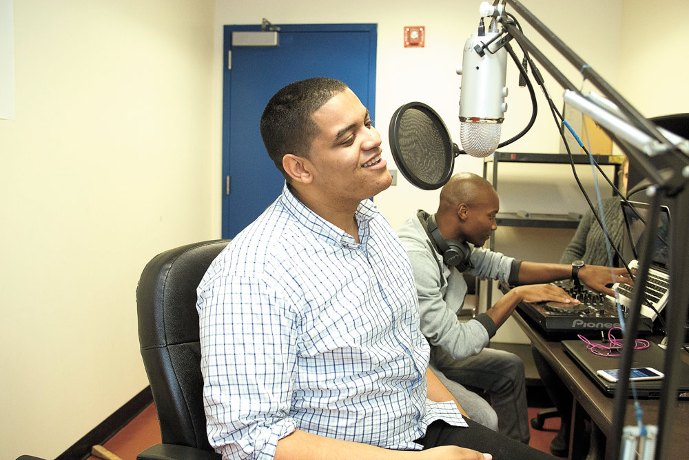 Erick Jhon Peguero, left, speaks into the microphone during a broadcast of a program he co-hosted with Poche Wilson, right, on Lehman College’s radio station in 2016. Some pirate broadcasters, however, take to decidedly underground means of reaching various audiences beyond legitimate radio’s so-called mainstream audience.