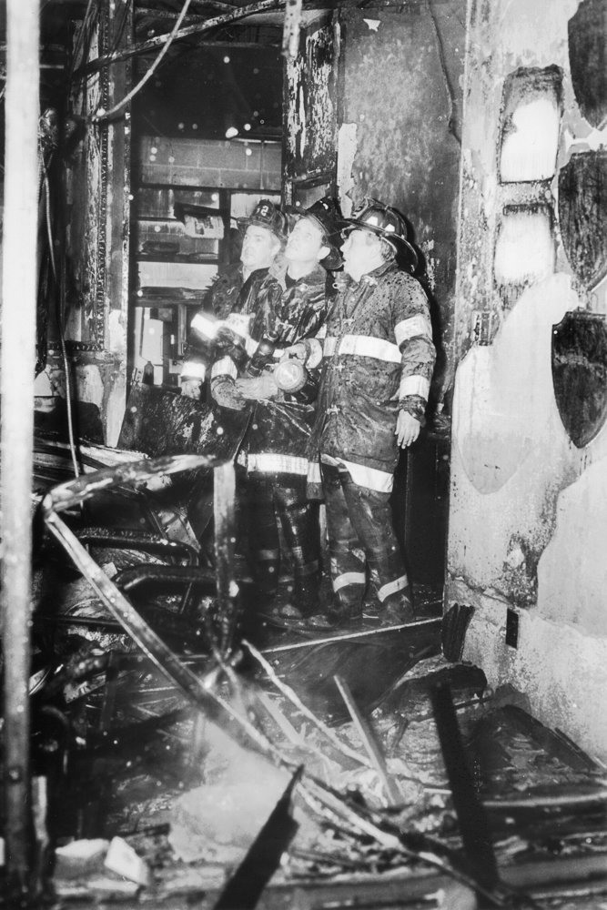 Firefighters analyze the damage inside the Broadway office of The Riverdale Press following the Feb. 28, 1989, firebombing.