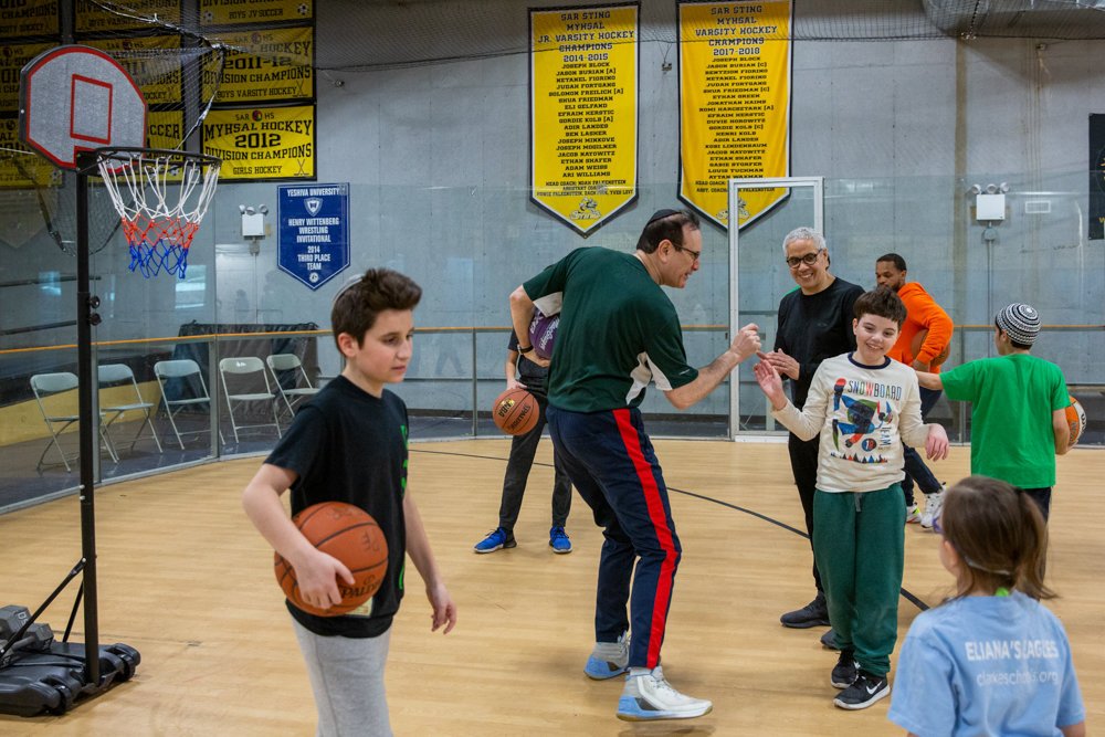 David Shapiro, holding a basketball at left, and volunteer Harold Brem, center, are part of a unique program called Inclusion Basketball, which benefits children with disabilities.