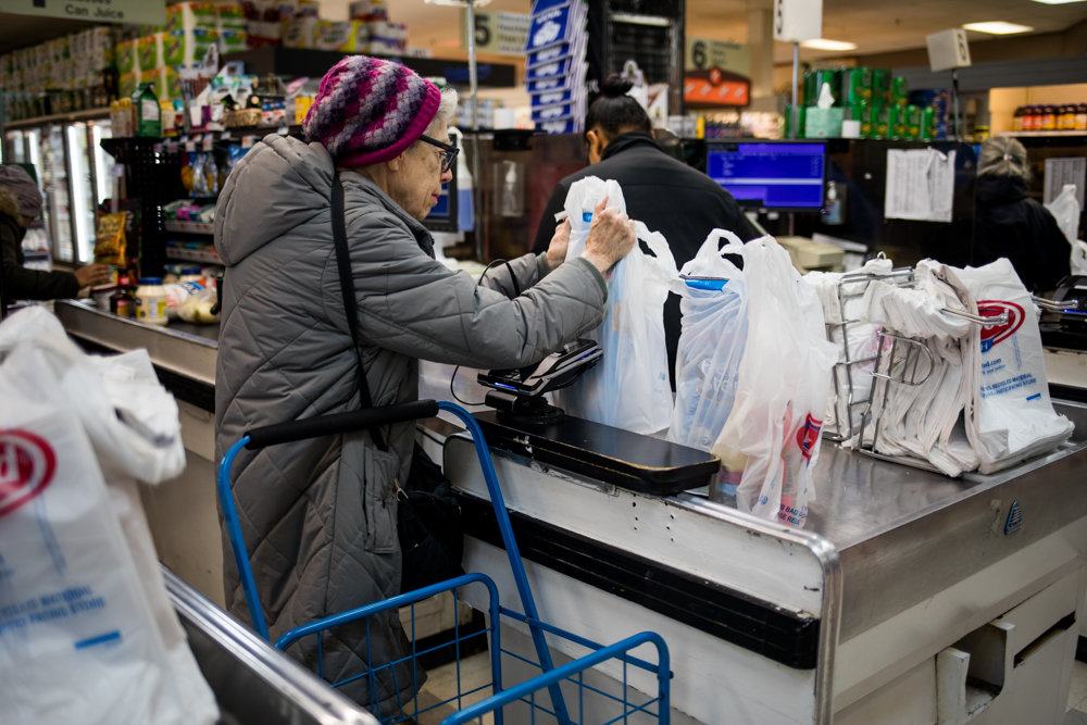 A customer collects her groceries in Key Food on Riverdale Avenue. As part of the state's new budget, lawmakers approved a ban on single-use plastic bags, part of an unusual power the governor has to enact policy through the budget process.
