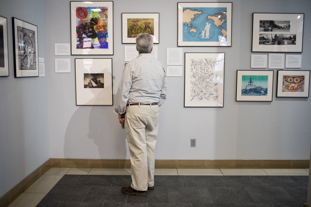 A visitor looks at artwork in 'Experiencing Veterans and Artists Collaboration,' an exhibition on display at Manhattan College's O'Malley Library through June 21.