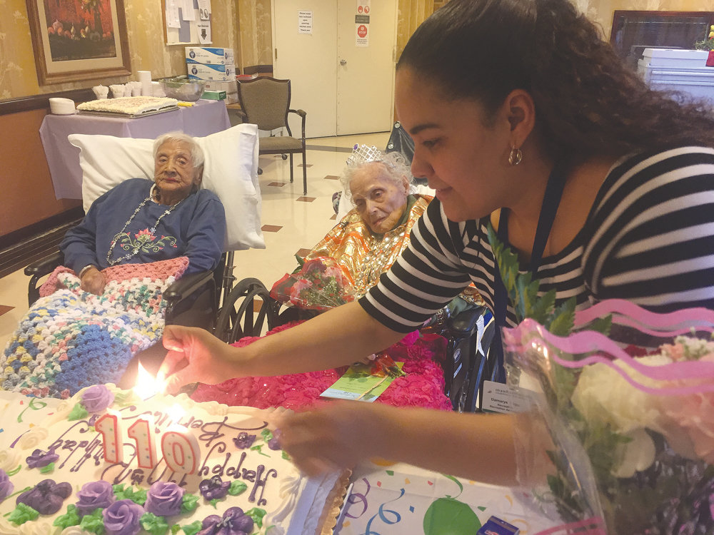Bernice King dons a tiara with a shiny gold and red shawl as she watches the candles lit for her 110th birthday cake at Manhattanville Health Care Center in 2017. King died March 28, just a week short of her 112th birthday.