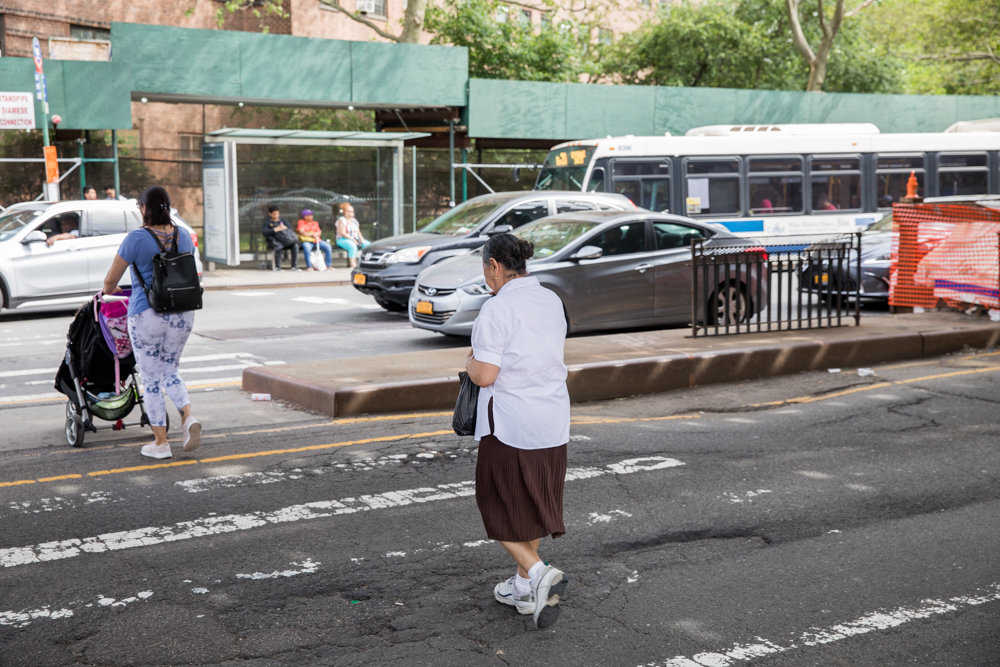 Pedestrians cross Broadway at West 230th Street while a Bx20 bus pulls to a stop. The city’s transportation department wants to install bus lanes on Broadway between West 225th and West 230th streets.