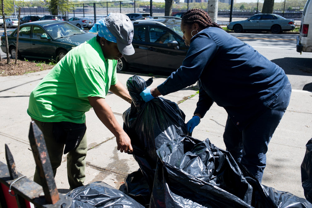 Kathy Rodriguez, left, and Kim Ryer clean up trash at Fort Four Park. Joel Guerrero has used the park since he was a kid, and now wants to give back by working to revamp the basketball courts there.