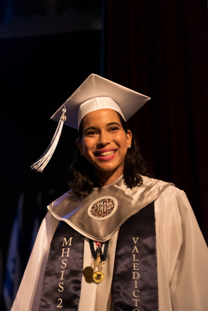 Angela Veras Oriach smiles as she leaves the stage after receiving an award during the graduation ceremony of Marble Hill High School for International Studies. Oriach was her class valedictorian.