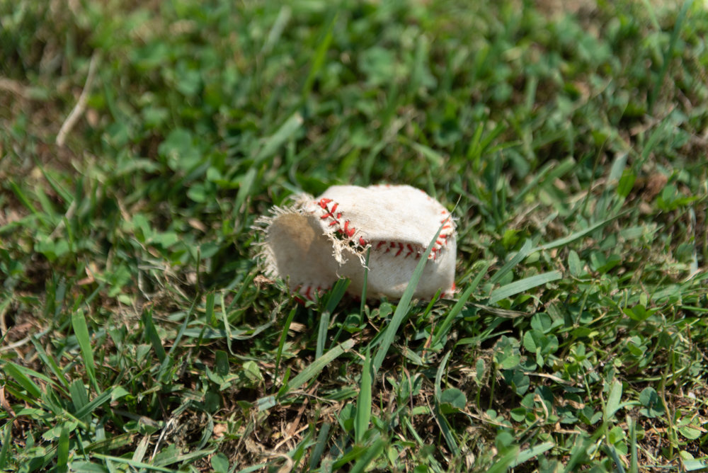 A torn baseball lies on the ground at the Van Cortlandt Park ballfield, which once was the home for Manhattan College’s team. The Jaspers now play home games more than 60 miles away in Dutchess County.