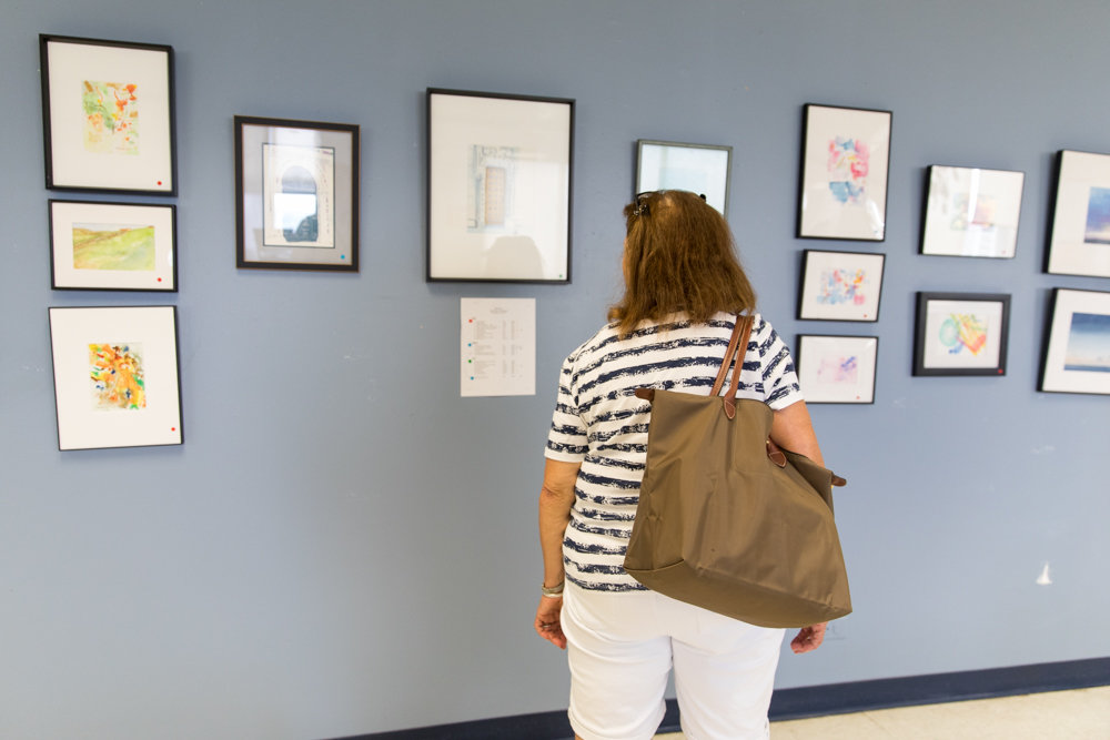 A visitor to RSS-Riverdale Senior Services looks at an exhibition of paintings by Ruth Hurd. The senior center is celebrating its 45th anniversary.