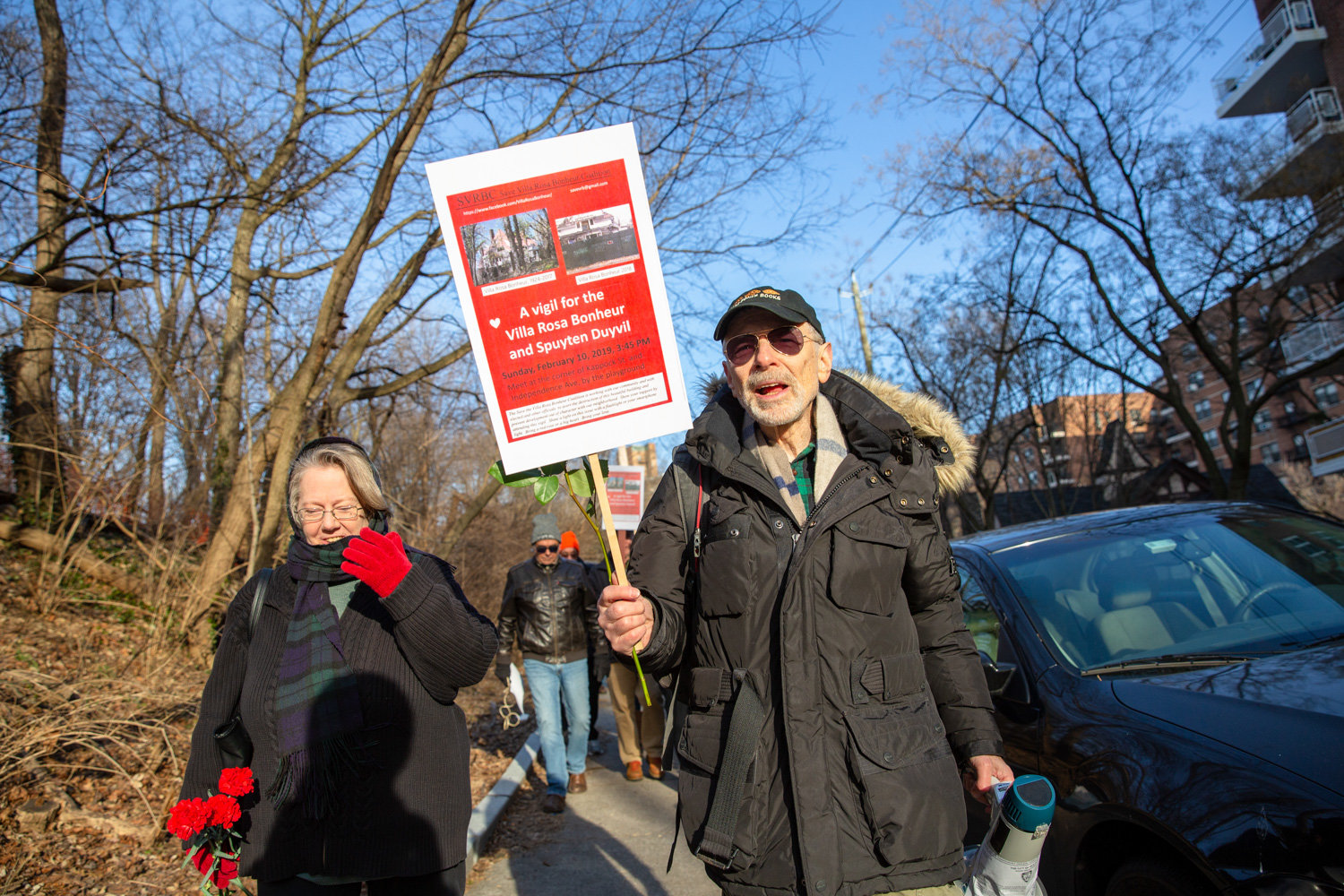 Perry Brass, right, and Jennifer Scarlott lead a group of community members toward the Villa Rosa Bonheur for a vigil in support of the historic apartment building in February. Brass lives in the Villa Rosa’s sister building, Villa Charlotte Bronte.