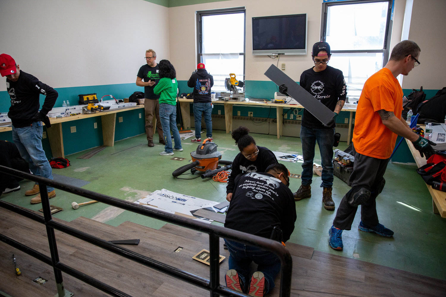 Volunteers from Rebuilding Together NYC and Local Union No. 3 IBEW resurface a classroom floor at the Kingsbridge Heights Community Center.
