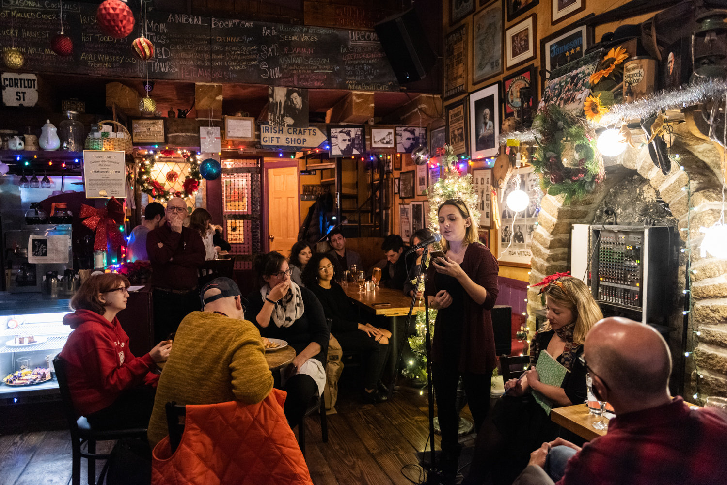 Melissa Wilson reads a poem at the 10-year anniversary celebration of the Poor Mouth Theatre Company’s writer’s night at An Beal Bocht Cafe on Dec. 11.