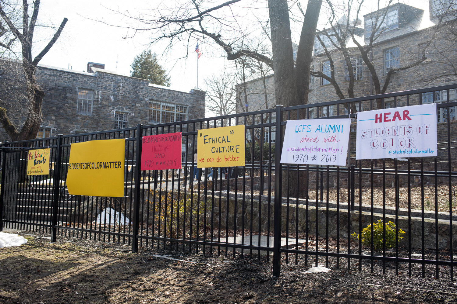 Signs expressing solidarity with the Students of Color Matter organization adorn a fence last year outside Ethical Culture Fieldston School. In the wake of a lawsuit over alleged systemic racism. Nearly a year later, the school is in the middle of another controversy following an outcry over a guest speaker’s alleged anti-Semitic remarks. The school subsequently fired history teacher J.B. Brager, reportedly over social media posts in relation to that controversy.