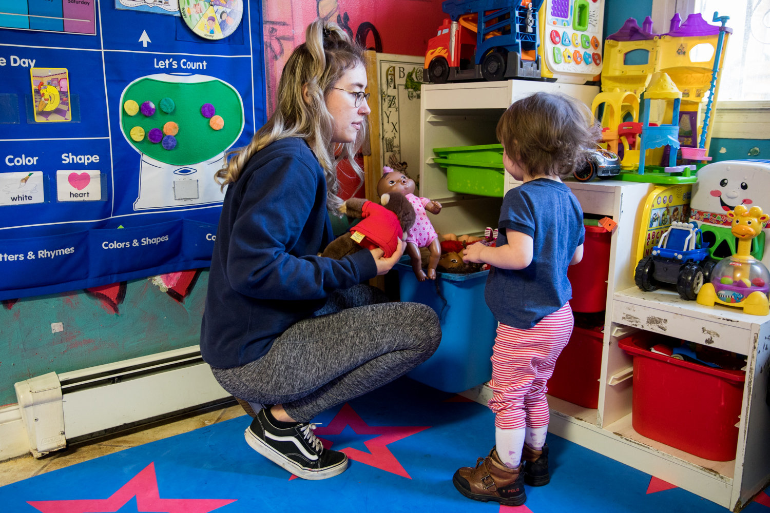 Rodi Daycare Center teacher Stephany Coffey offers a child a choice of toys. Rodica Chiacu, the center’s owner, understands that child care can be expensive, and has worked to keep her rates affordable for parents.
