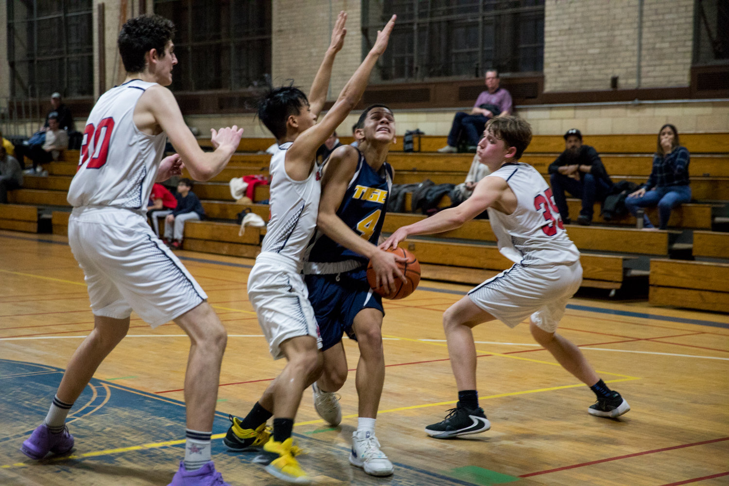 Riverdale/Kingsbridge Academy’s Ethan Bonet slices through a pair of American Studies’ defenders during the Tigers’ 49-38 win over the Senators. Bonet finished with 12 points and 16 rebounds.