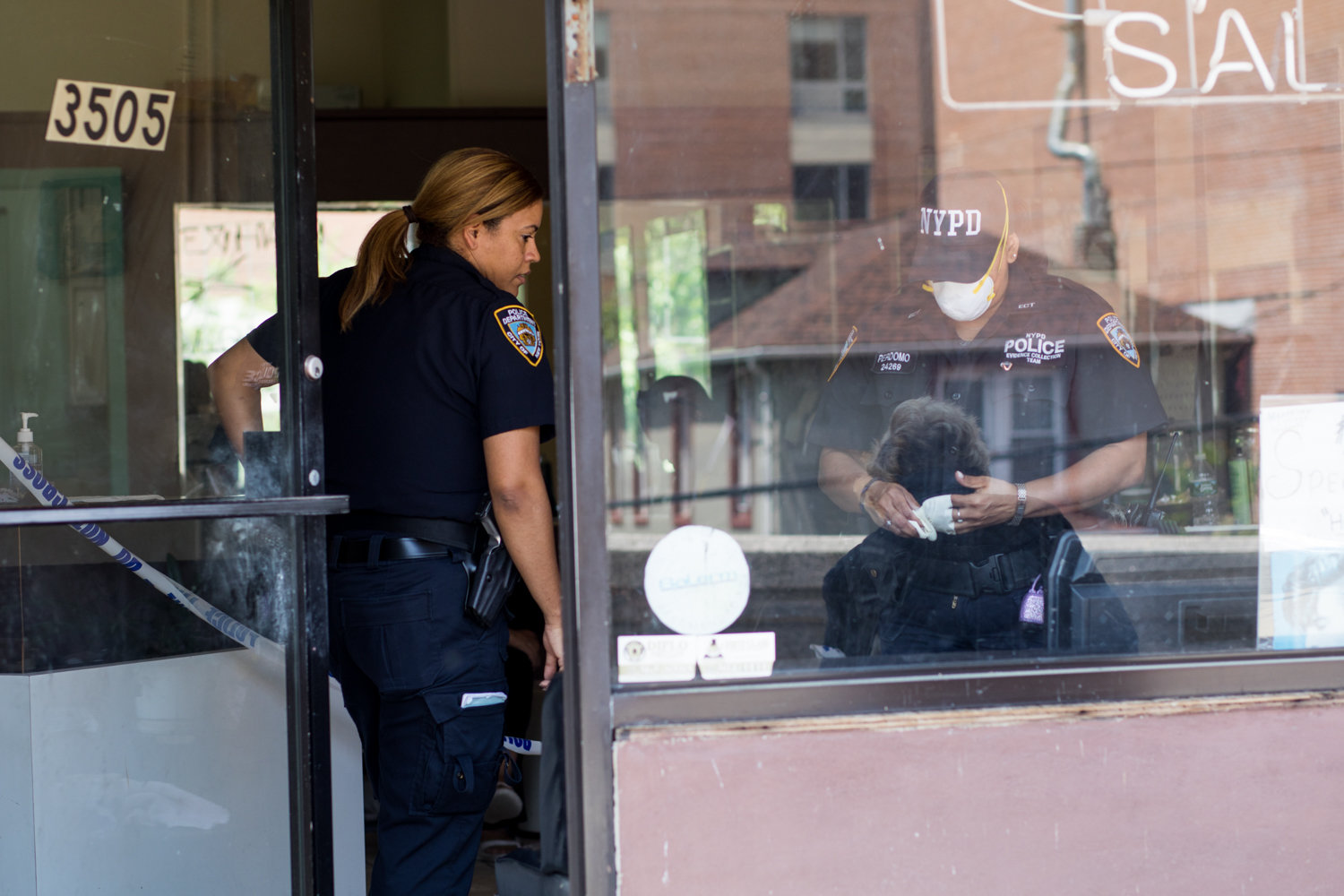 Police officers investigate a crime scene at Park Terrace Unisex Salon on Riverdale Avenue, one of three businesses targeted by a robber in June 2018.
