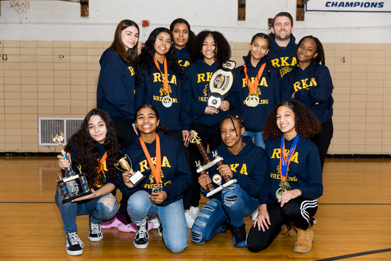 Riverdale/Kingsbridge Academy wrestling coach Michael Lepetit poses with some of his girls that have helped make the Tigers’ middle and high school wrestling teams so successful.