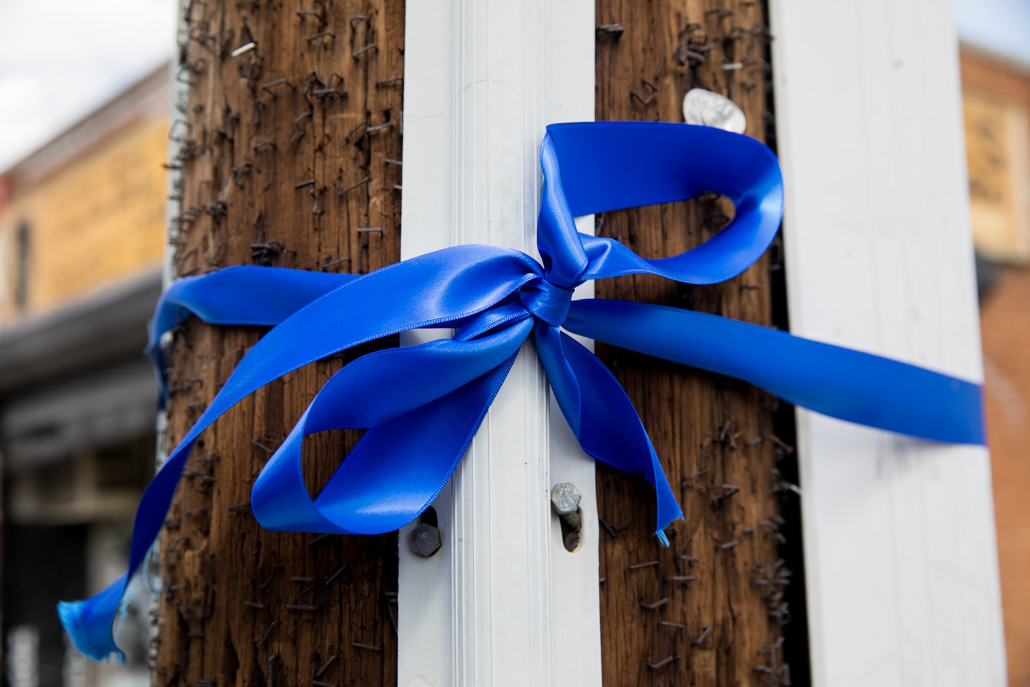 A blue ribbon is wrapped around a pole on West 259th Street and Riverdale Avenue. The ribbon is part of a thank you campaign expressing gratitude to essential workers and those on the health care front lines from the Riverdale Main Streets Alliance.