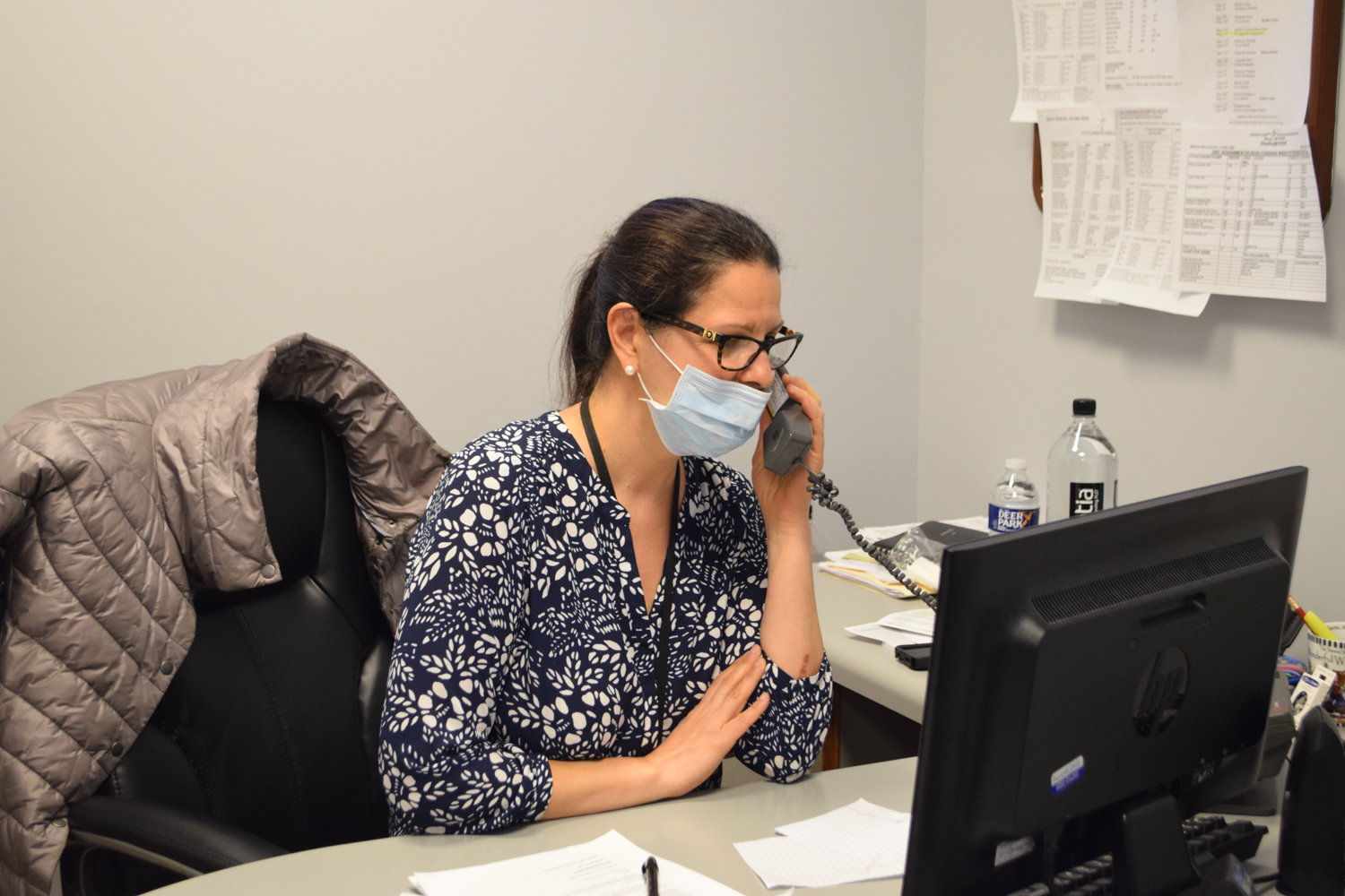 Evangeline Anastasiou, social services supervisor at the Hebrew Home at Riverdale, wears personal protective equipment at her desk. Since the advent of the coronavirus pandemic, the Hebrew Home has lost 25 residents from confirmed or suspected complications related to COVID-19.