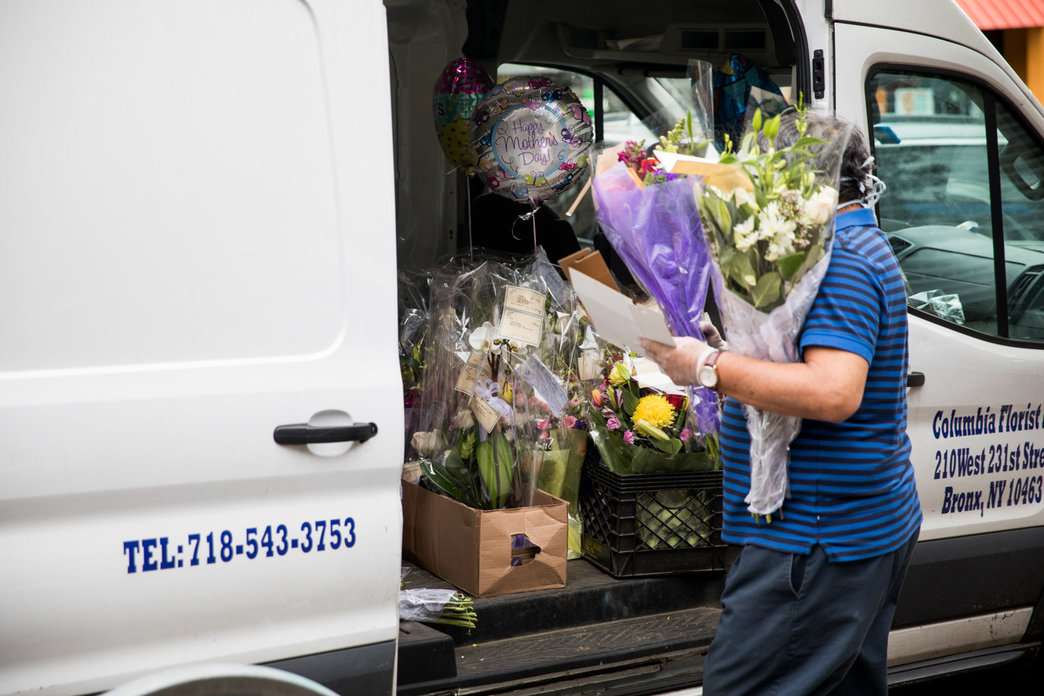 A worker carries an order of flowers to a van from Columbia Florist two days before Mother’s Day.