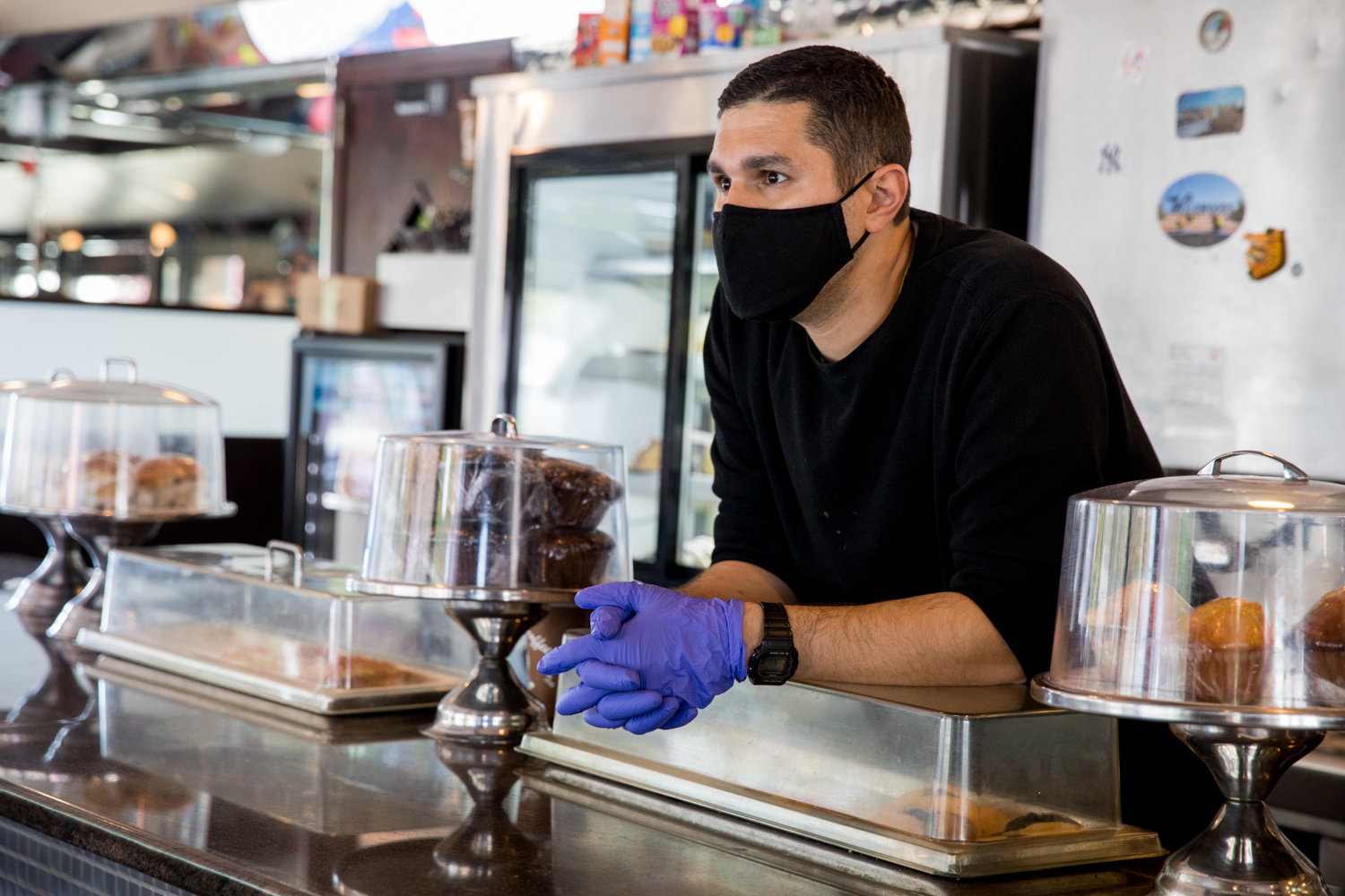 Nick Diakakis looks out from behind the counter at Tibbett Diner, which has been struggling in the face of the coronavirus pandemic. While it has reopened for takeout and delivery, business is not what it used to be.