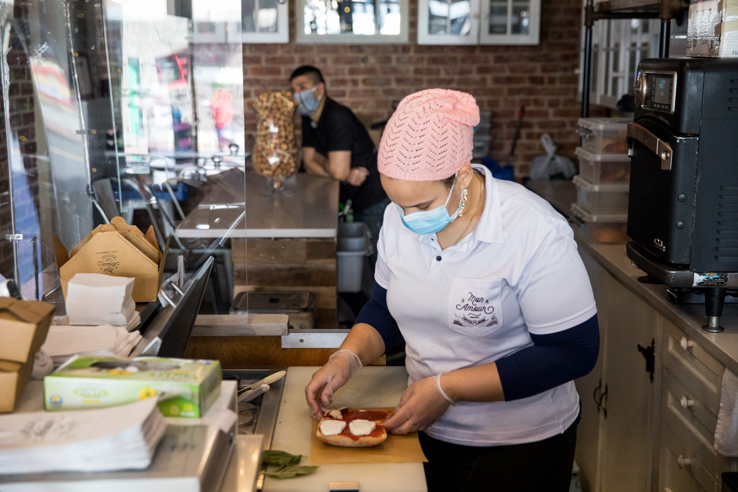 Yolanda Almonte prepares a sandwich inside Mon Amour Coffee & Wine, which was closed for nearly two months following the statewide shutdown as a result of the coronavirus pandemic.