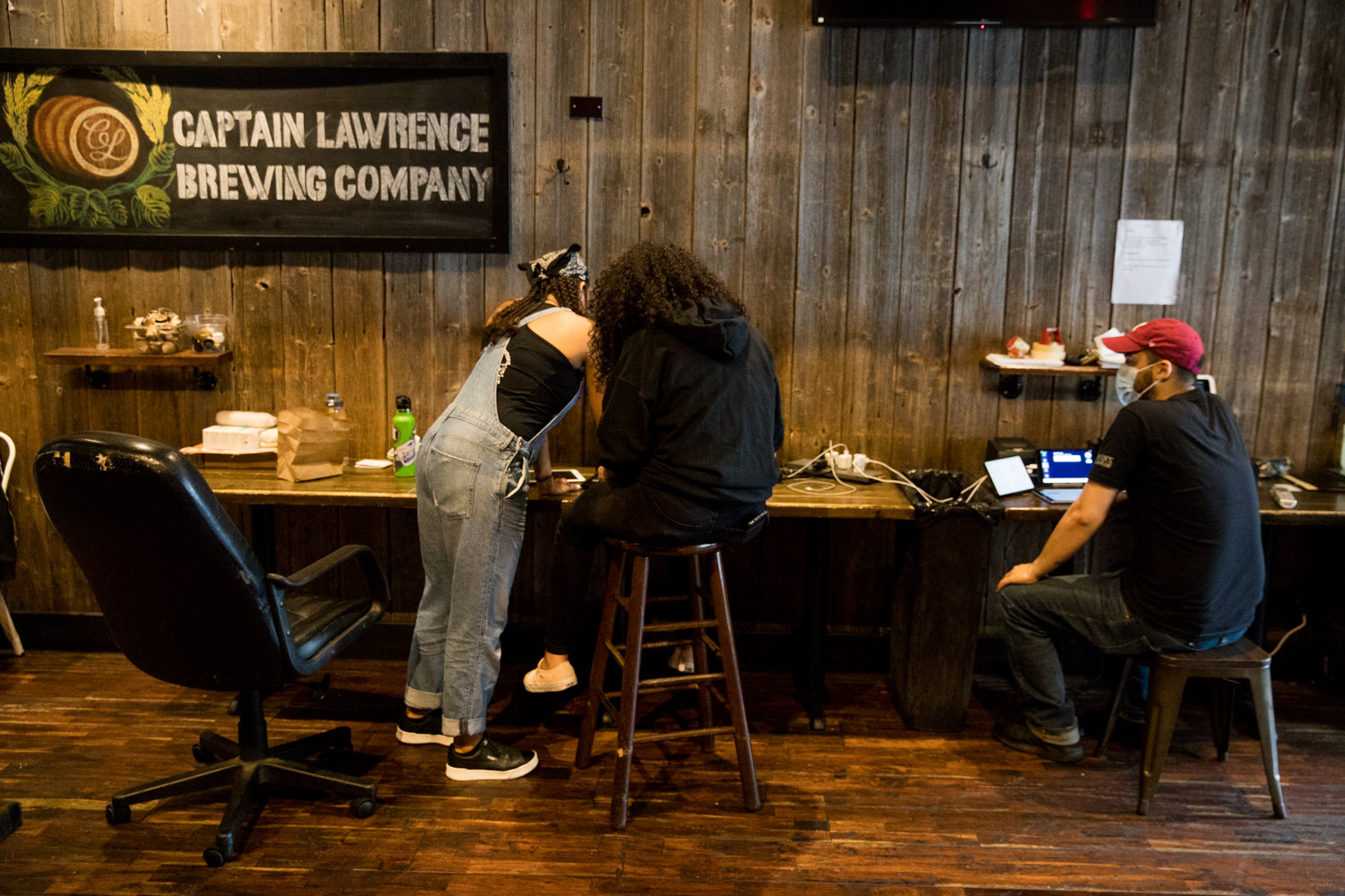 Dom Jackson, left, Irene Luna and Kenneth Burgos work inside the Bronx Alehouse, one of a number of small businesses that has managed to stay open during the coronavirus pandemic.