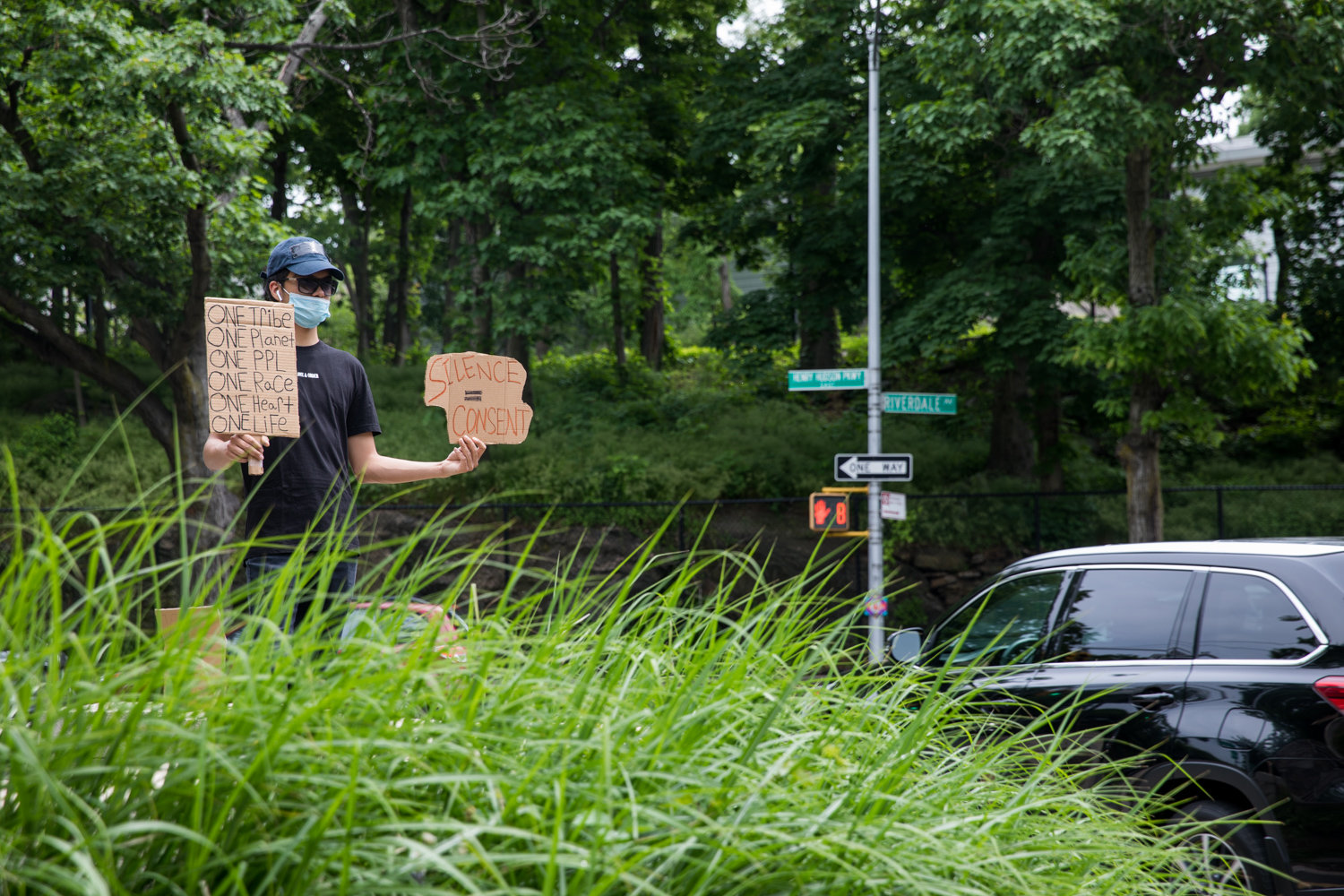 A car passes by the Riverdale Monument as James Cortez holds up signs in support of the Black Lives Matter movement. It was part of an ongoing vigil, organized following the police-involved death of George Floyd in Minneapolis, allowing people 20-minute shifts in the community center, to accommodate for coronavirus social distancing.