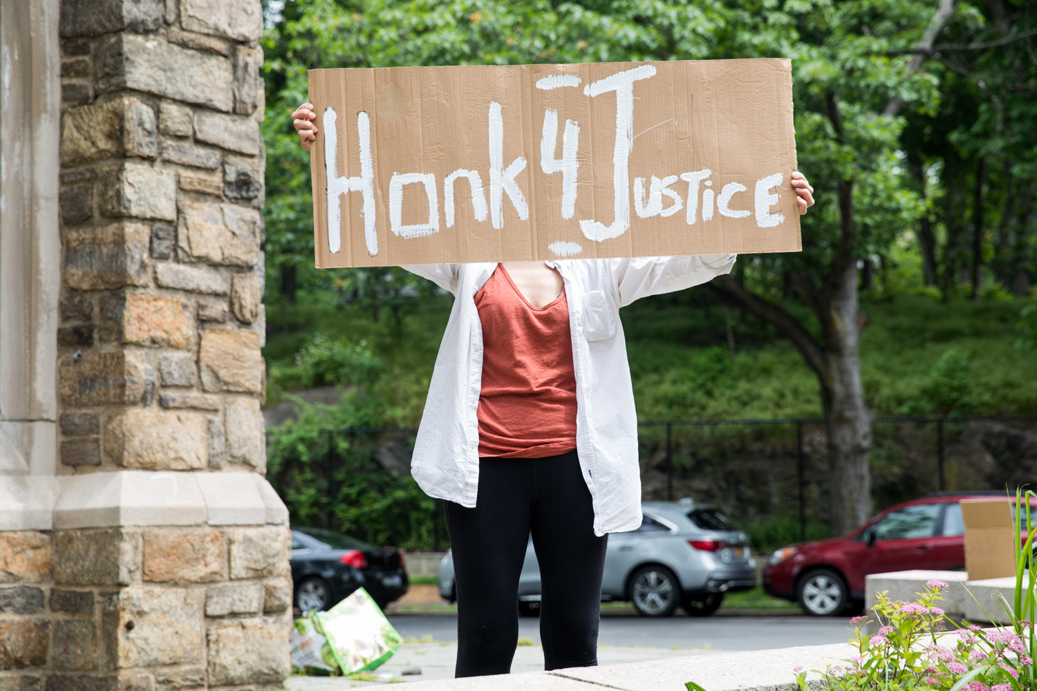 A community member holds up a sign that reads ‘honk 4 justice’ at the Riverdale Monument. He was part of an ongoing vigil organized following the police-involved death of George Floyd in Minneapolis.