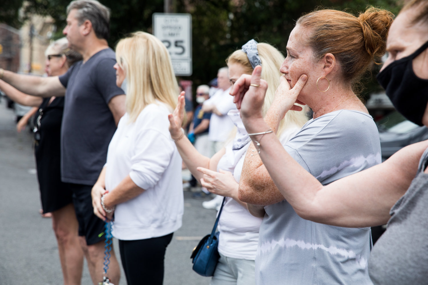 Mourners wave at a funeral procession for the late Michael Rooney on Mosholu Avenue. The procession down the avenue where Rooney lived was organized in light of the coronavirus pandemic to give those who knew him a chance to gather.