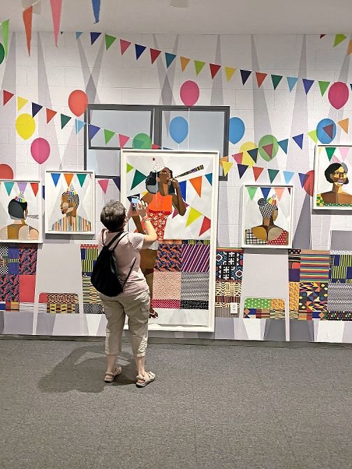 A visitor to the Hudson River Museum in Yonkers takes pictures of the recent Derrick Adams exhibit ‘Buoyant,’ which was reopened to the public at a limited capacity of 40 people. The museum has continued new exhibits and performances via its Amphitheater program, which accommodates 50 people, as the performance space is outside.
