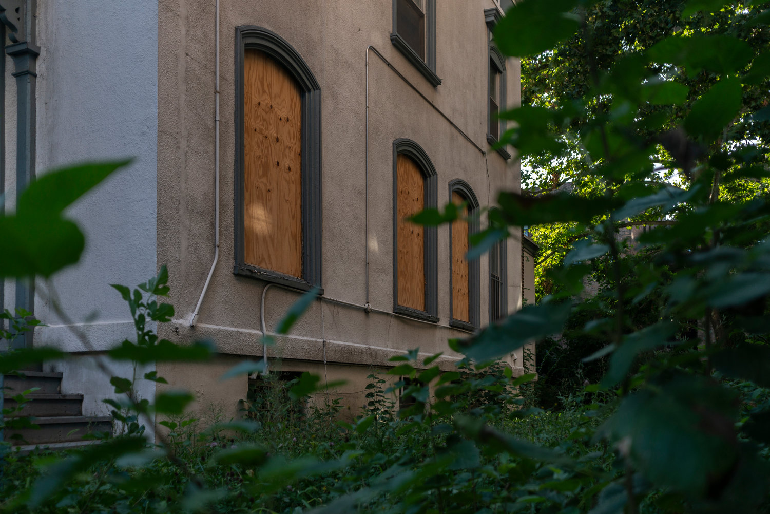 Over the lowest points of the stone walls surrounding the Moller Mansion, passersby can see some of the boarded-up windows of the longtime convent at 3029 Godwin Terrace.