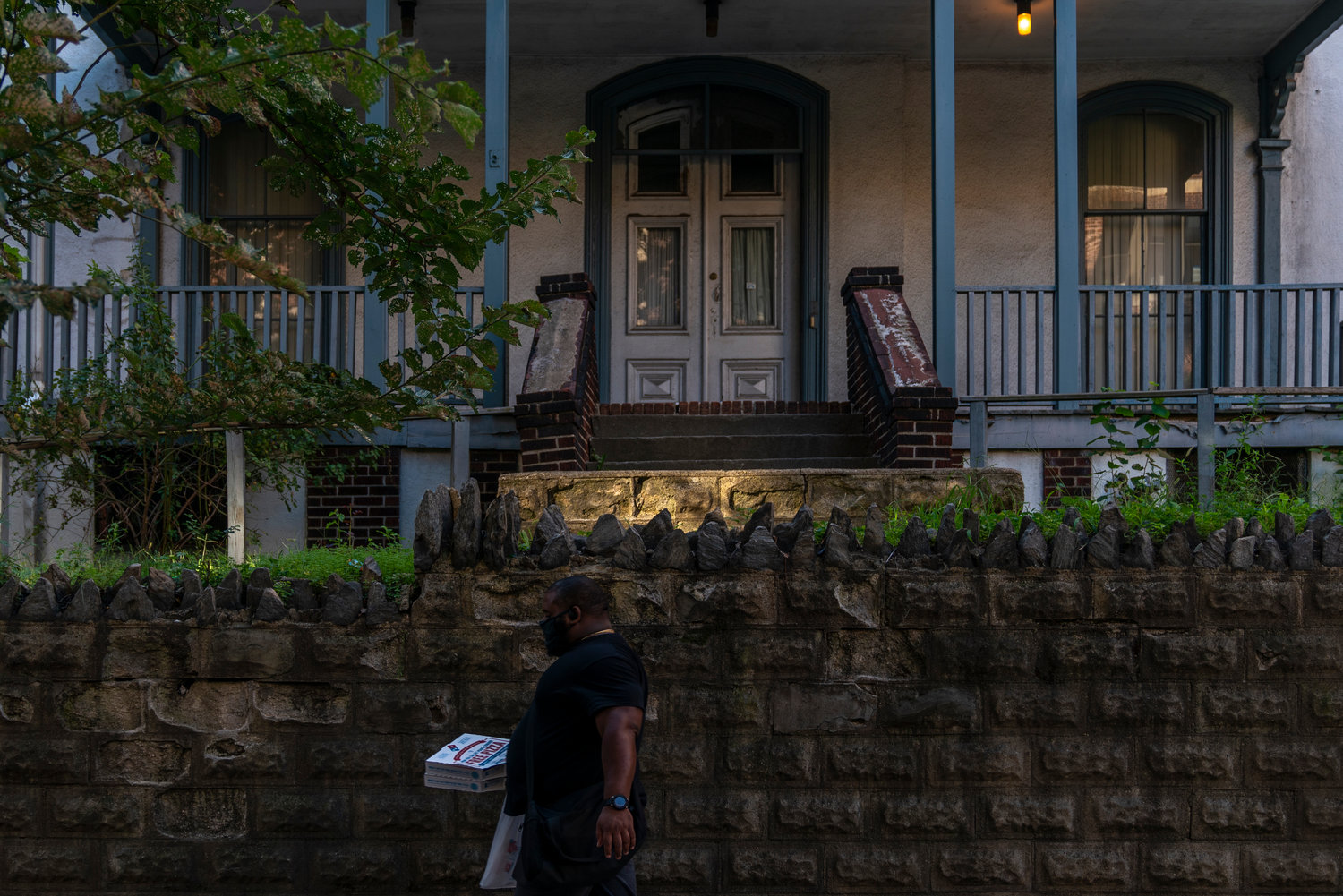 A person walks past 3029 Godwin Terrace with a pair of pizzas in hand, creating a much different streetscape than what the Moller family saw when they first moved in back in 1870.