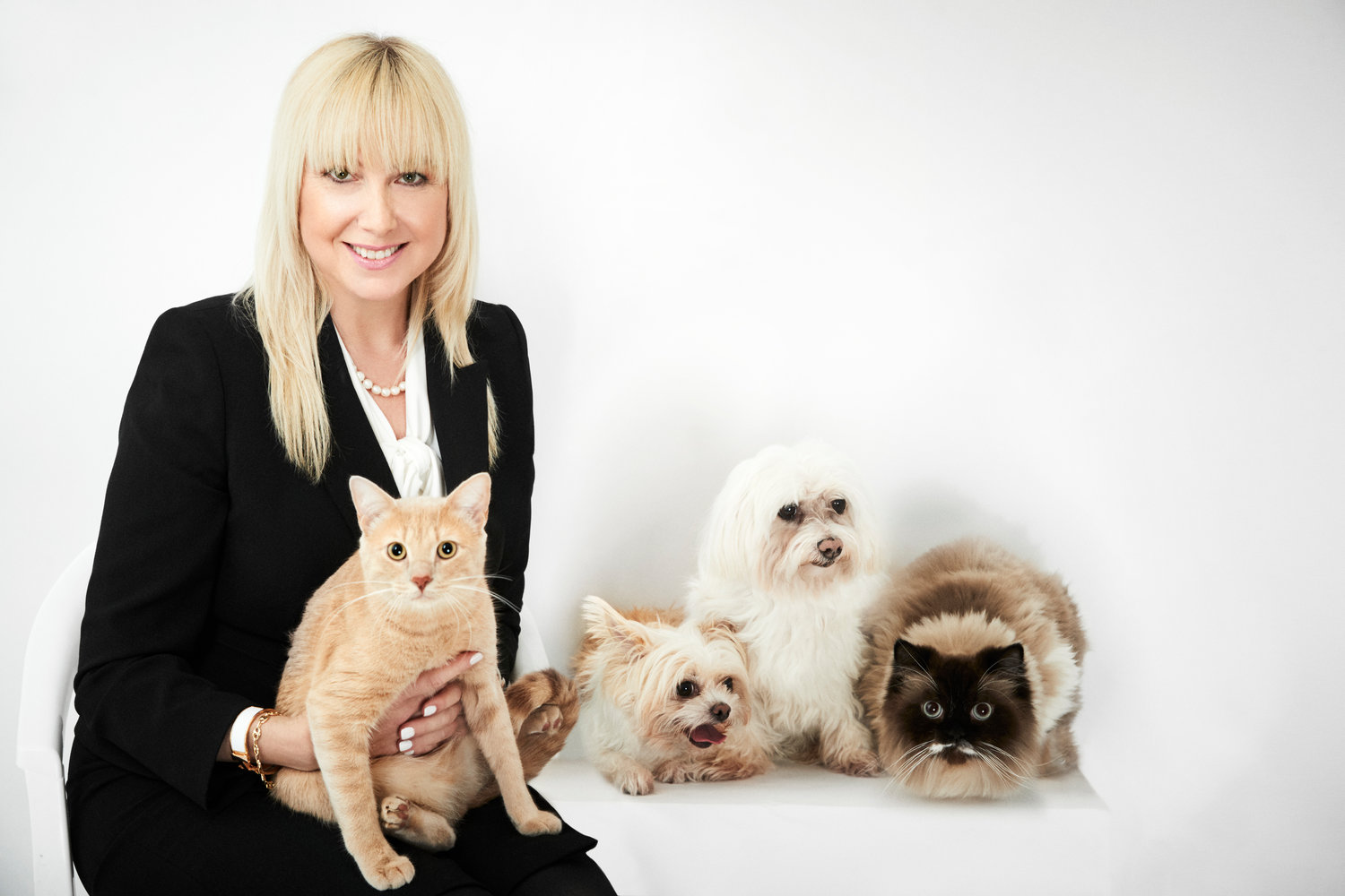 Julie Hyman poses for a portrait with four pets after placing a winning bid on the Humane Society NY Gala sponsored session.