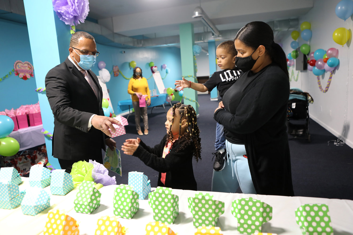 Andre Coleman, the program director at the Broadway Family Plaza transitional housing facility gives a cupcake to Karla’s children, McKenzly and McKayson, during a Mother’s Day event last week. The event was part of a produce drive organized by Kingsbridge Unidos, a mutual aid group ensuring families get fresh vegetables in this part of the Bronx.