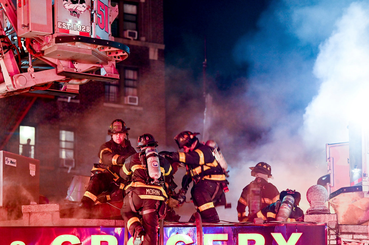 Firefighters make their way to the roof of Bailey Deli & Grocery in an effort to try and save the popular bodega on the corner of West 238th Street and Bailey Avenue. Investigators believe the fire started at a neighboring take-out restaurant, and quickly severely damaged five businesses along that stretch of Bailey.