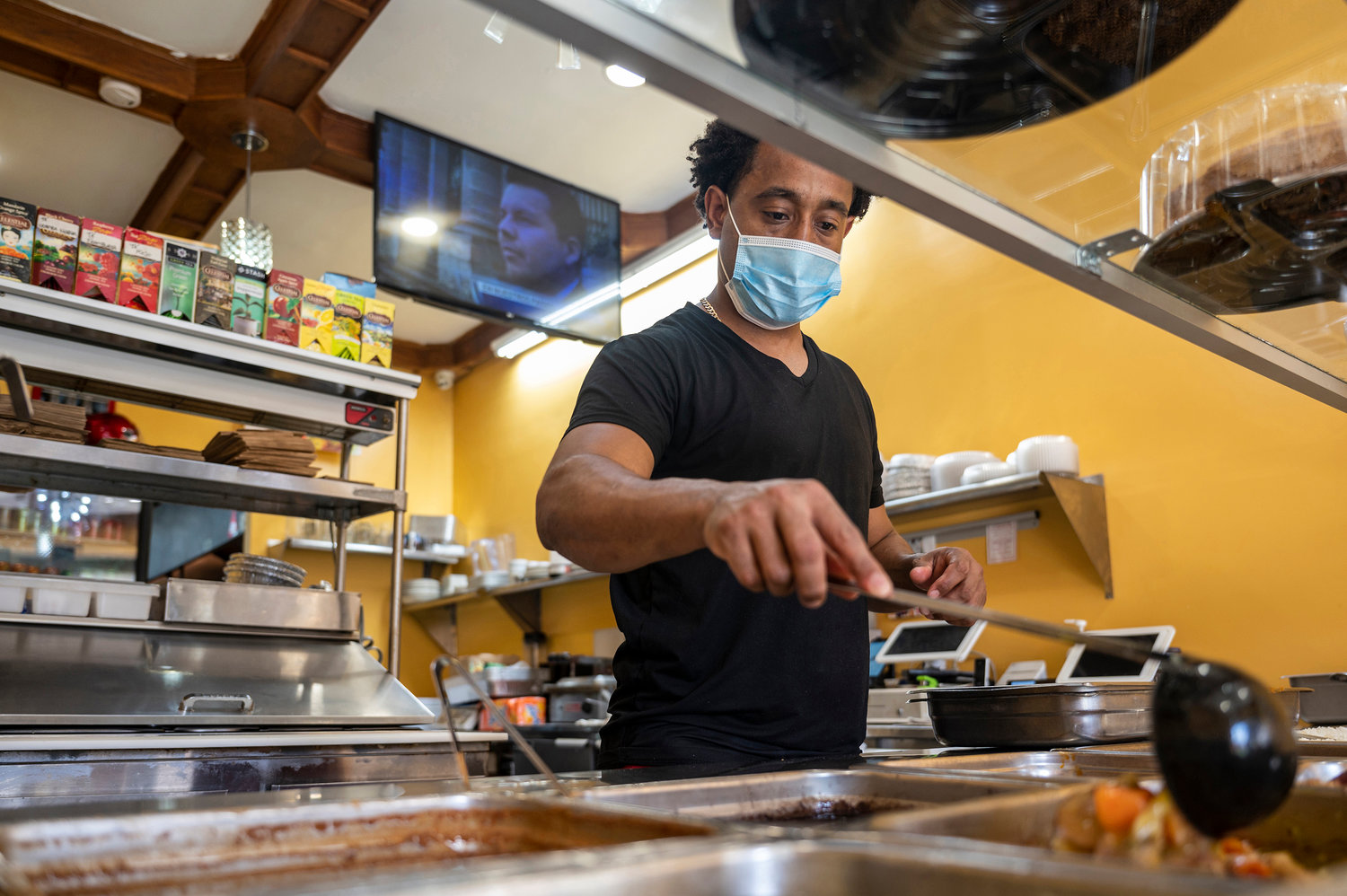 Julio Rosario prepares a meal at Con Sabor Latino at 3652 Bailey Ave., in June. The restaurant was one of two Latin cuisine eateries destroyed by a four-alarm fire last week.