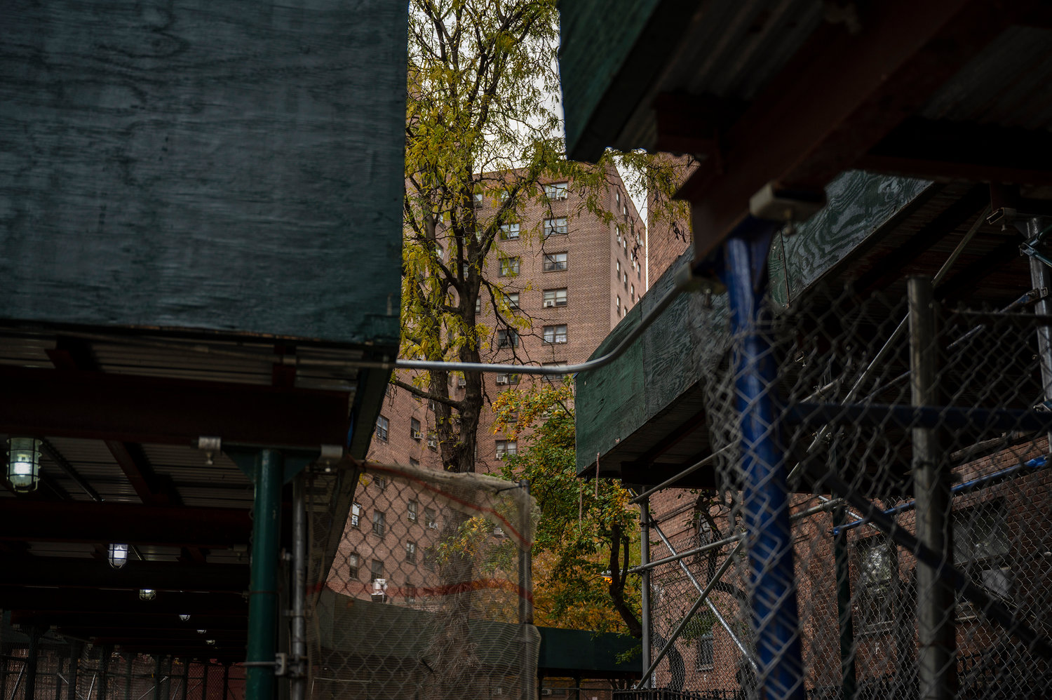 Sidewalk sheds line the perimeter of the buildings at Marble Hill Houses. Tenants say despite some benefits — like protecting pedestrians on the ground from debris falling from above — the structures are an eyesore and have overstayed their welcome.