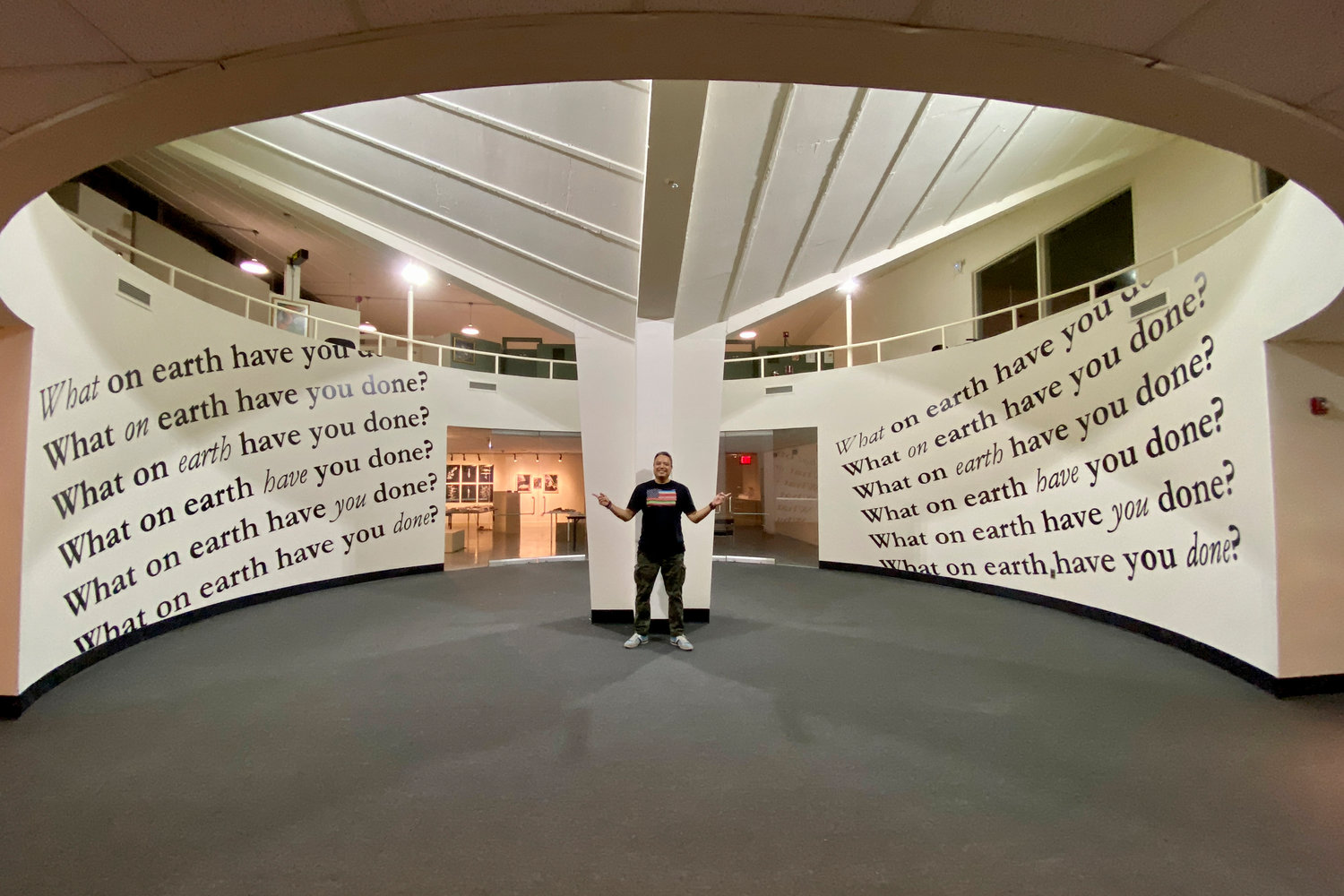 Nicky Enright stands next to his installation, ‘What On Earth? (Have You Done),’ which asks viewers to question their role in causing the climate crisis. This work is a part of ‘Eco-Urgency: Now or Never,’ a show looking at the impacts of climate change.