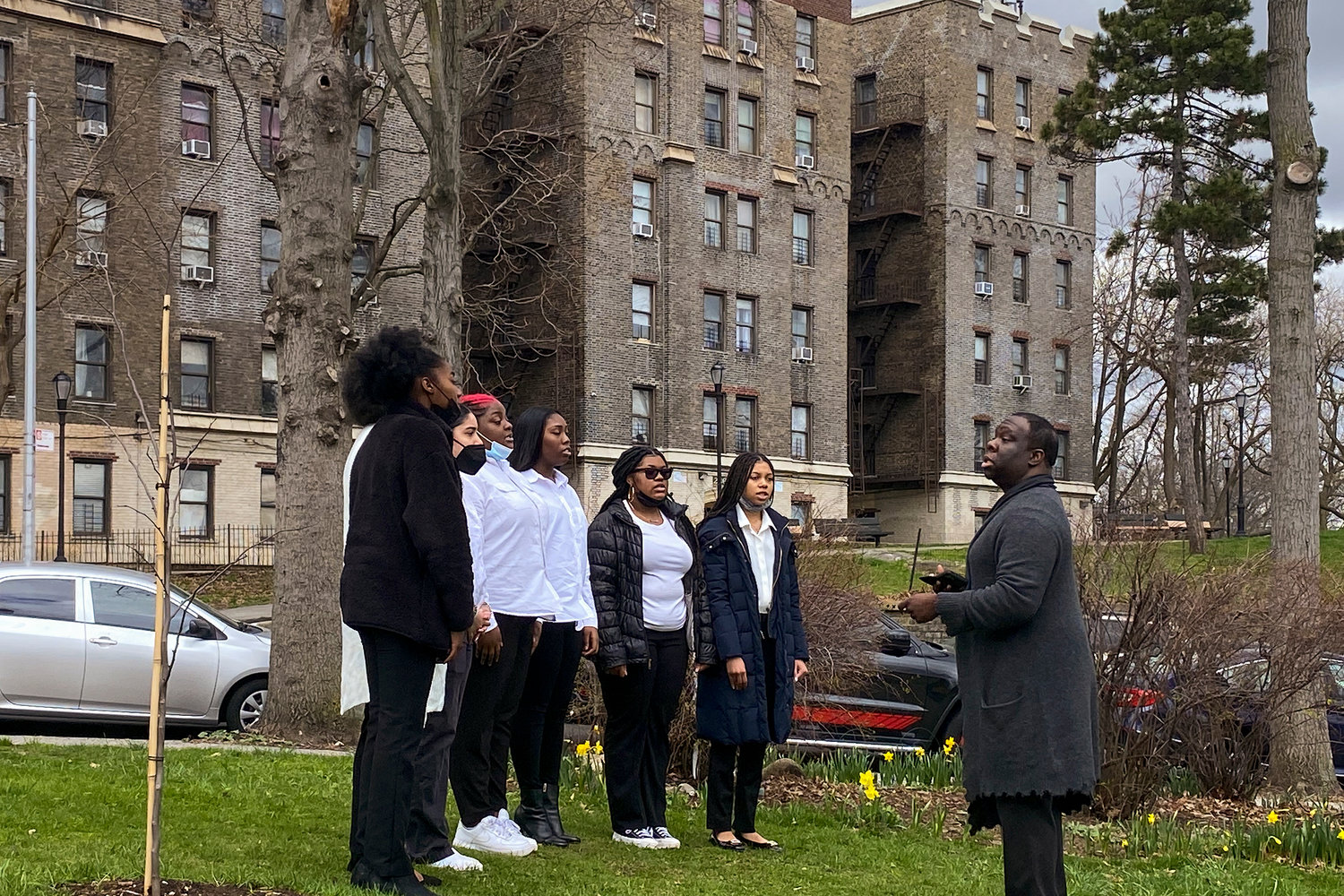 Celia Cruz Bronx High School of Music choir director Justin Kelly leads the school’s choir during a recent ceremony commemorating the blessing of three rosebud trees planted in the memory of New York City residents who died during COVID-19. The ceremony took place in a park at the corner of University and Reservoir avenues in Kingsbridge Heights.