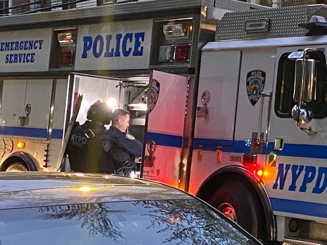 Police in the emergency service truck hand out equipment to officers heading into the basement of the Kingsbridge home where a man was fatally shot.