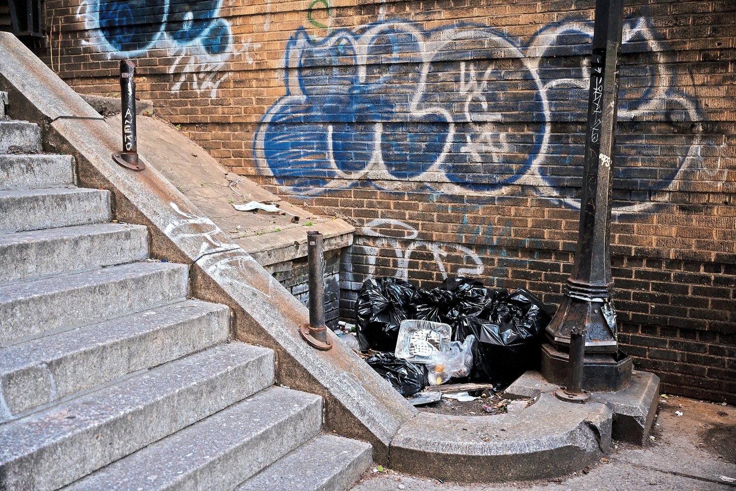 Piles of trash at the foot of the Godwin Terrace steps on Monday, May 9, 2022.