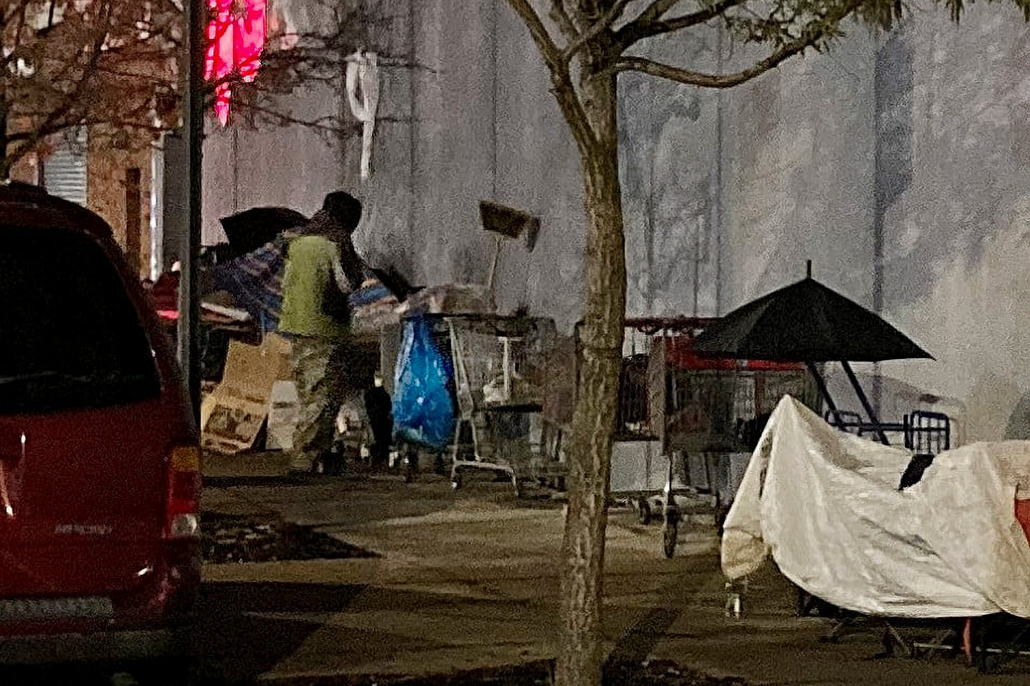 A homeless person tends to his belongings along the intersection of West 236th Street and Broadway recently. The city’s department of sanitation has cleared out that area since.
