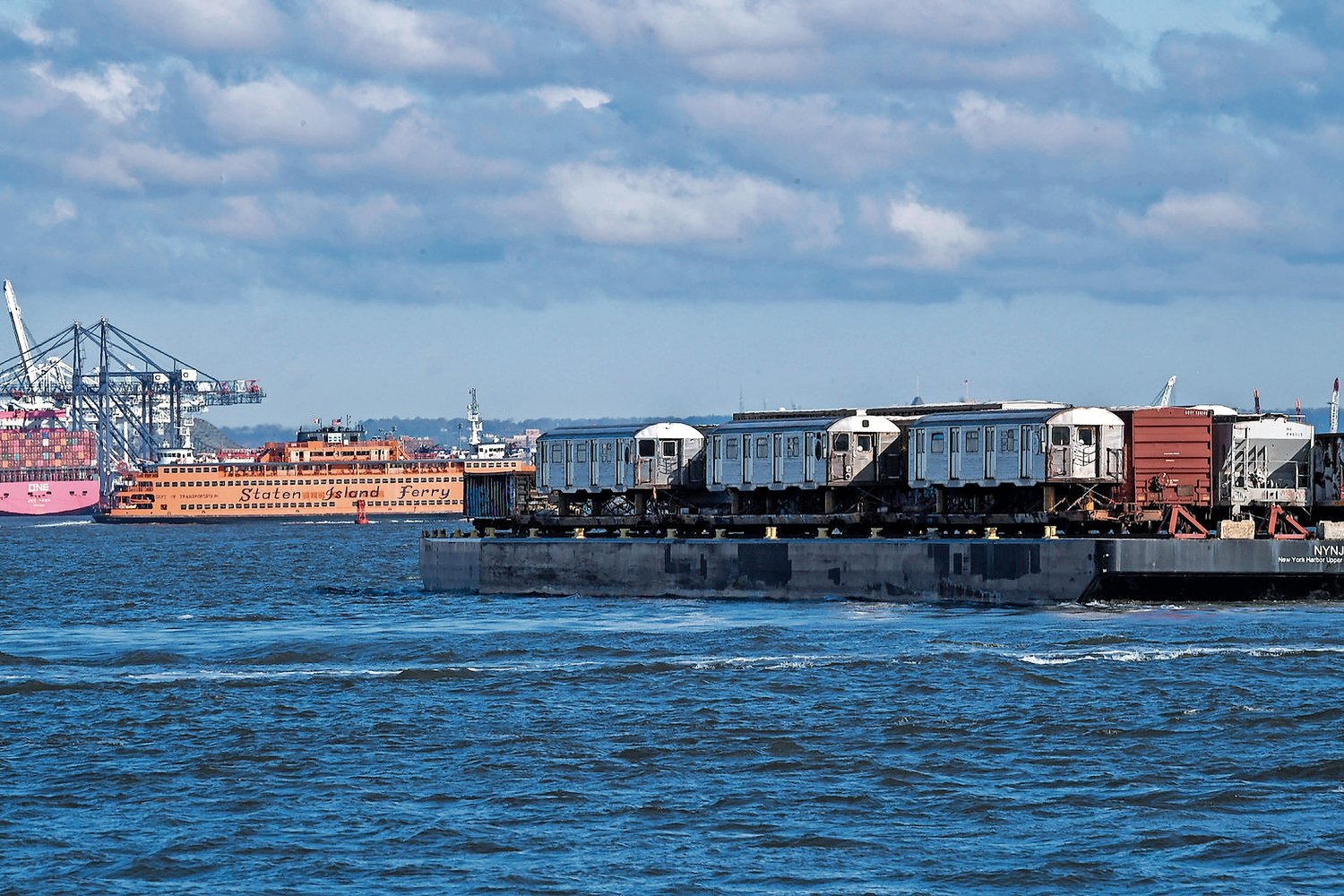 Six decommissioned R32 subway cars are moved from the 65th St. Yard by New York New Jersey Rail aboard a car float bound for Greenville Yard on Thursday, May 5, 2022. The cars are en route to their final destination in Ohio for scrapping.