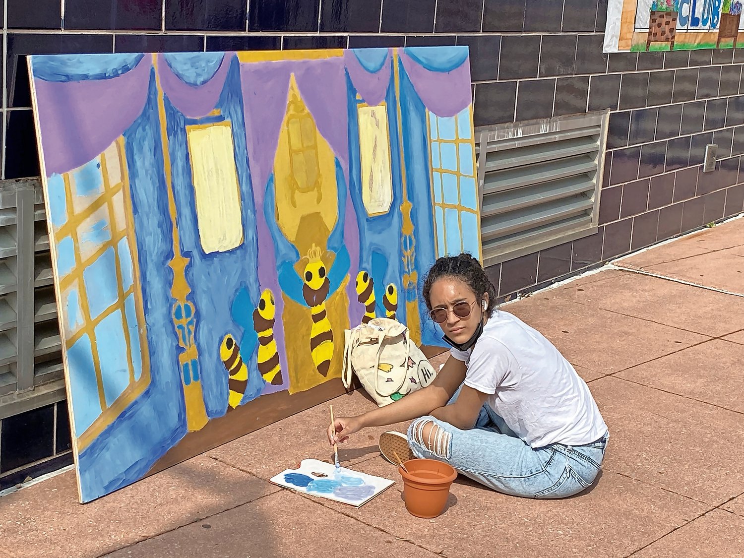 Junior Analix Corona of IN-Tech Academy adds some touch-ups to a painting called 'a European-style family portrait with bees' during Saturday's gardens groundbreaking.