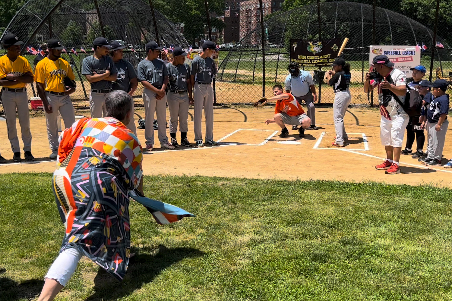 Deb Derella Cheren threw out the first pitch for opening day of the Van Cortlandt Park Baseball League on Saturday, June 4. A GoFundMe set up in her late husband Ivan’s honor is helping local baseball families afford the costs of travel, equipment and private lessons.