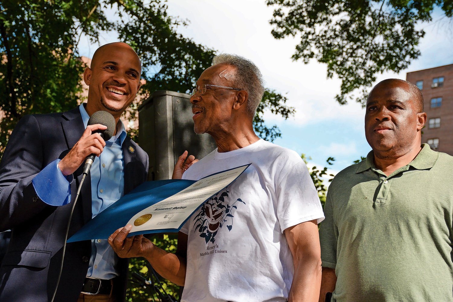 Assemblyman Manny de los Santos, at left, presents a citation to Rosey Spivey, center, on Saturday for exemplary service on behalf of his community as Marble Hill tenants association president Tony Edwards, right, looks on.