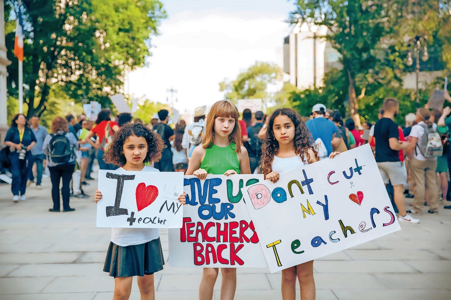 Emma Hoff, middle, a fourth-grader, at P.S. 24 Spuyten Duyvil, joins her friends in a show of support for her teachers at a June 24 rally in front of city hall.