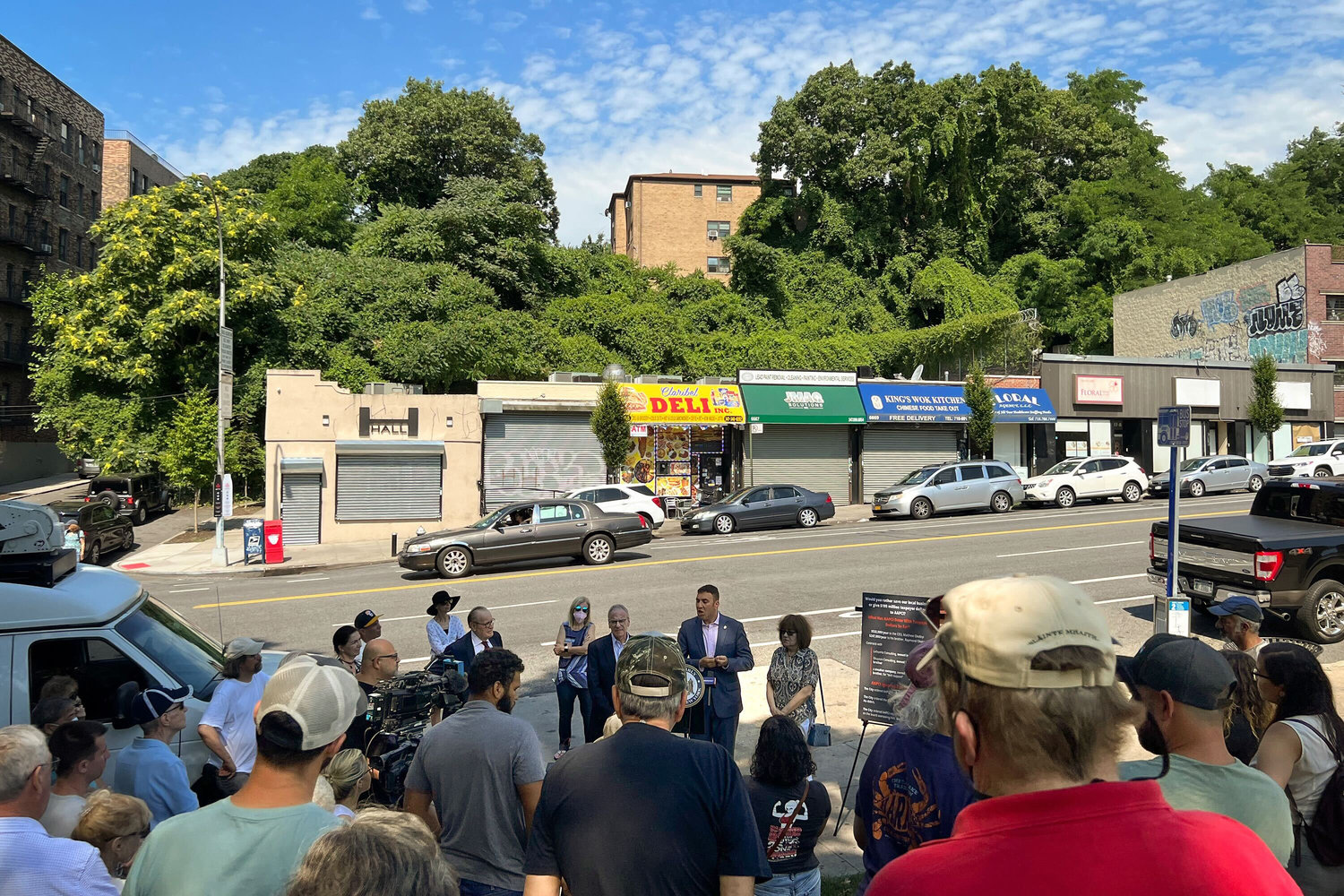 As state and city officials brief residents about their call for an investigation into the proposed men’s homeless shelter, in the background you can see the six storefronts that would be affected and have already received notice to vacate by the end of the year.