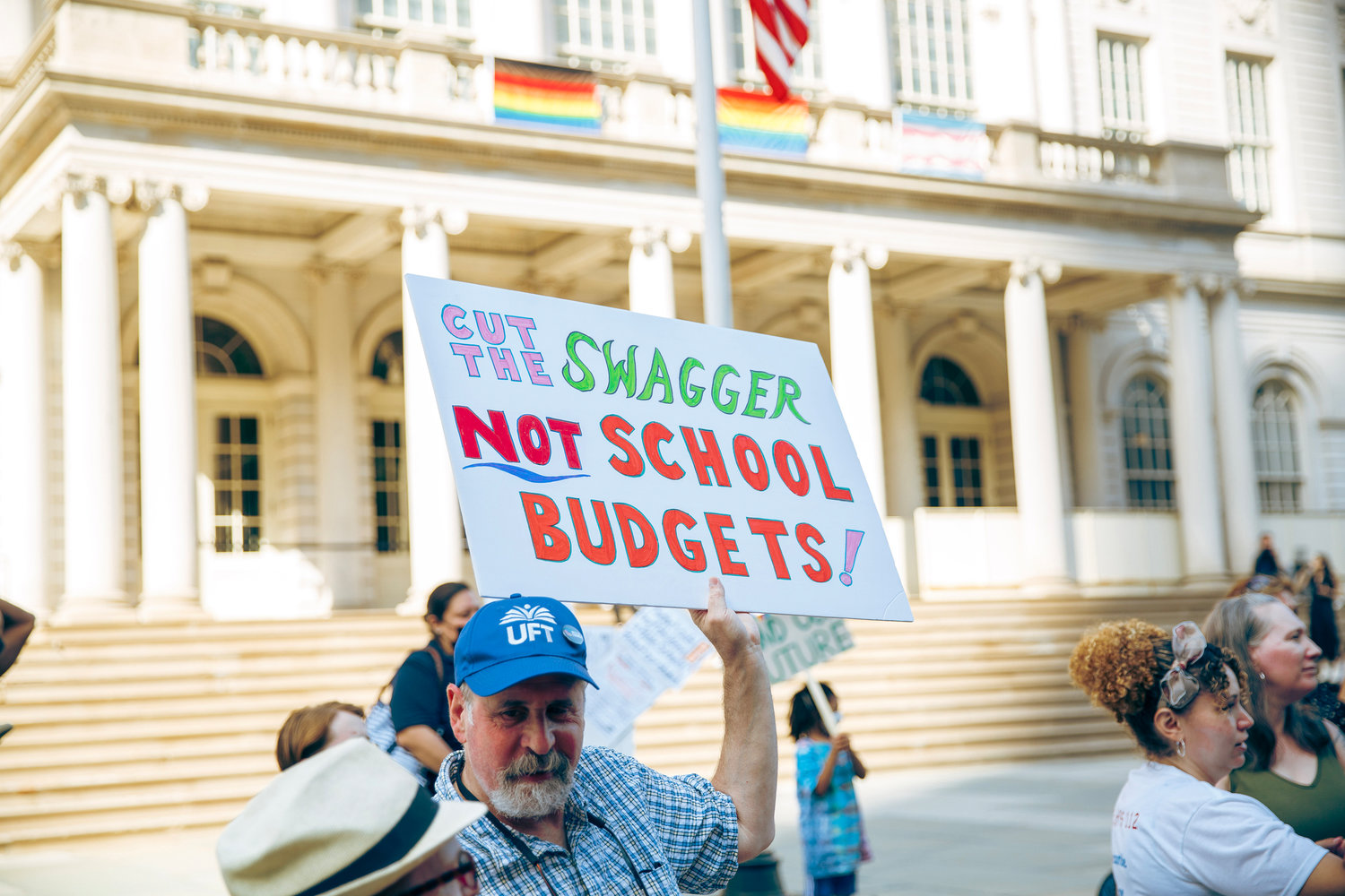 A New York City resident protests outside City Hall last month when the city council and the mayor approved more than $215 million in cuts for the upcoming school year.