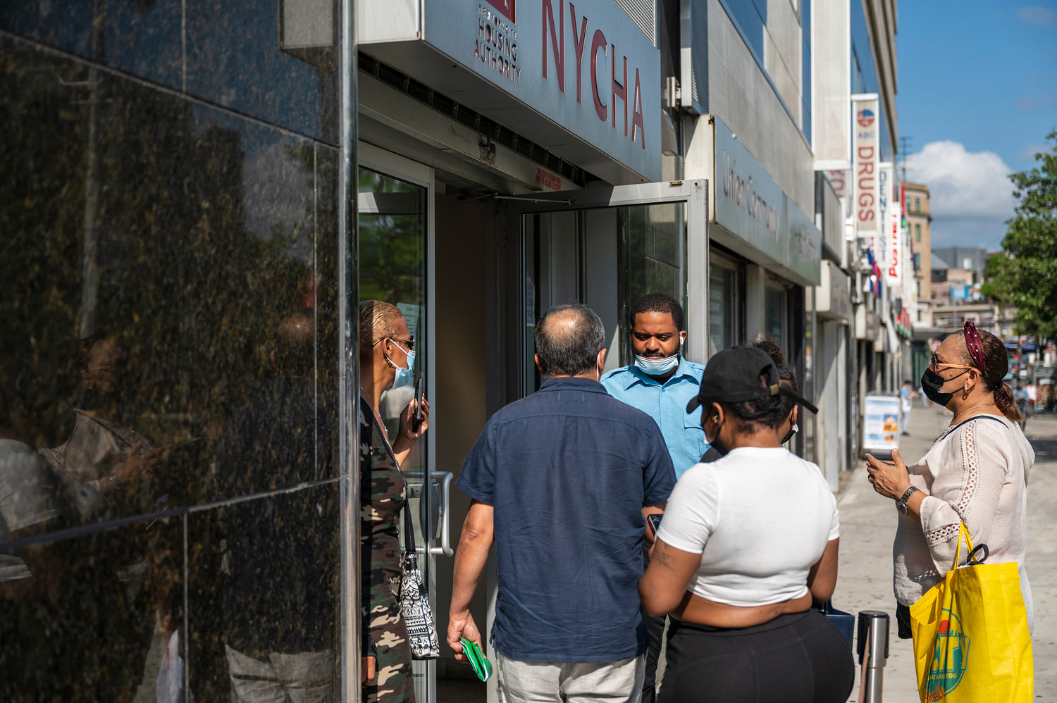 A security guard manages the line outside of NYCHA’s Customer Contact Center on Monday.