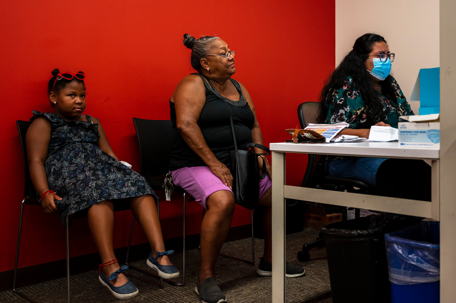 Yessica Flores, a caseworker at Part of the Solution, helps clients Nellie Chacon and her granddaughter Cherish Chacon on a Monday afternoon with her Section 8 voucher issue.